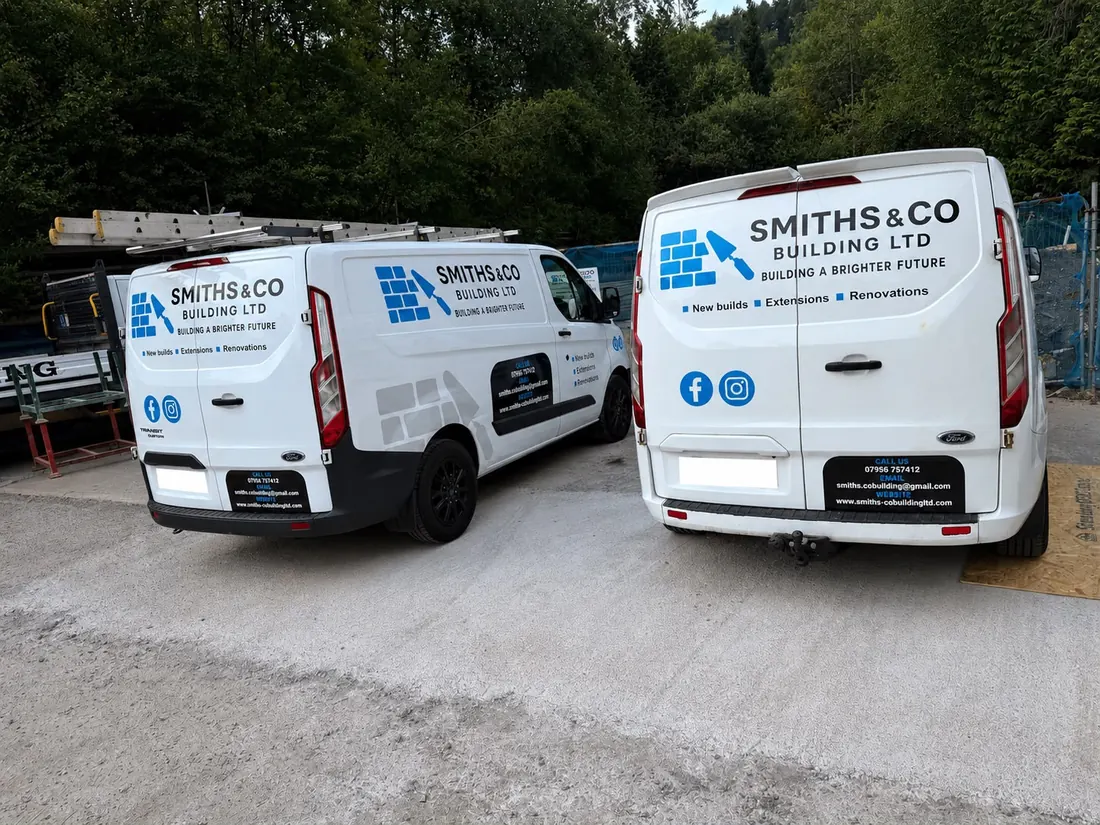 Two Smiths & Co Building Ltd branded vans parked side by side, signwritten with the company name, services and contact details