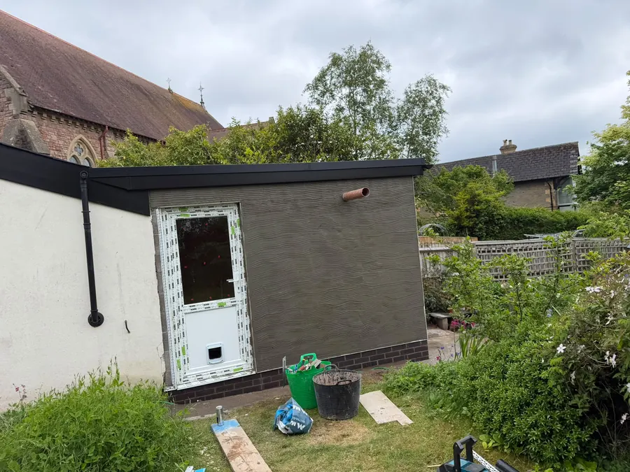 A finished rear extension viewed from the garden, render and grey trim