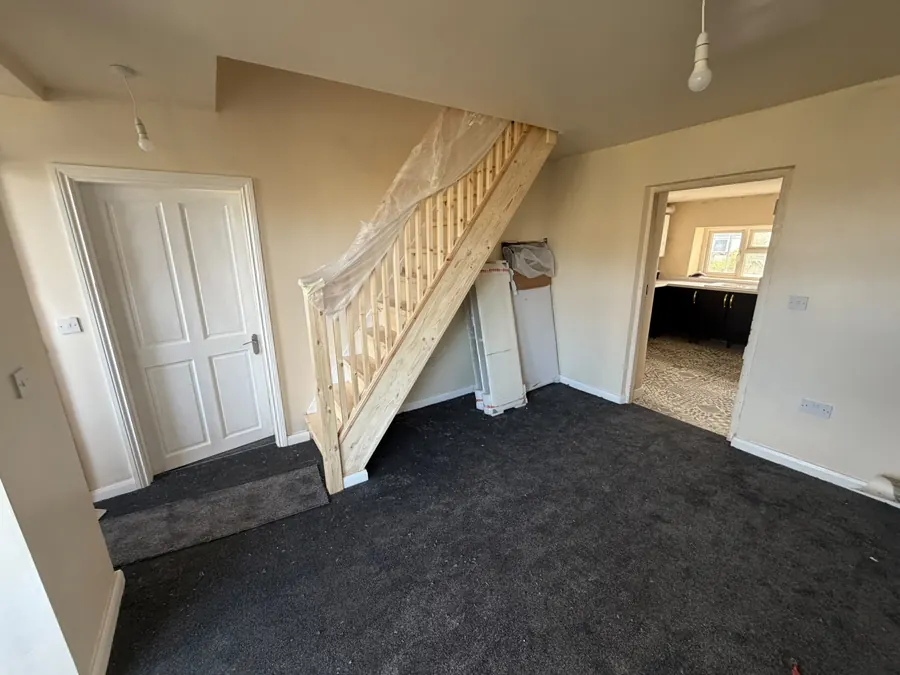 A finished hallway and staircase, decorated and carpeted