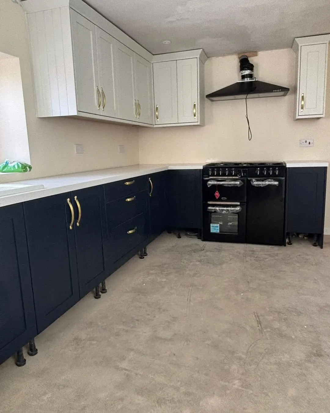 The same kitchen earlier in the fit-out, with units and range cooker in place and the floor not yet laid