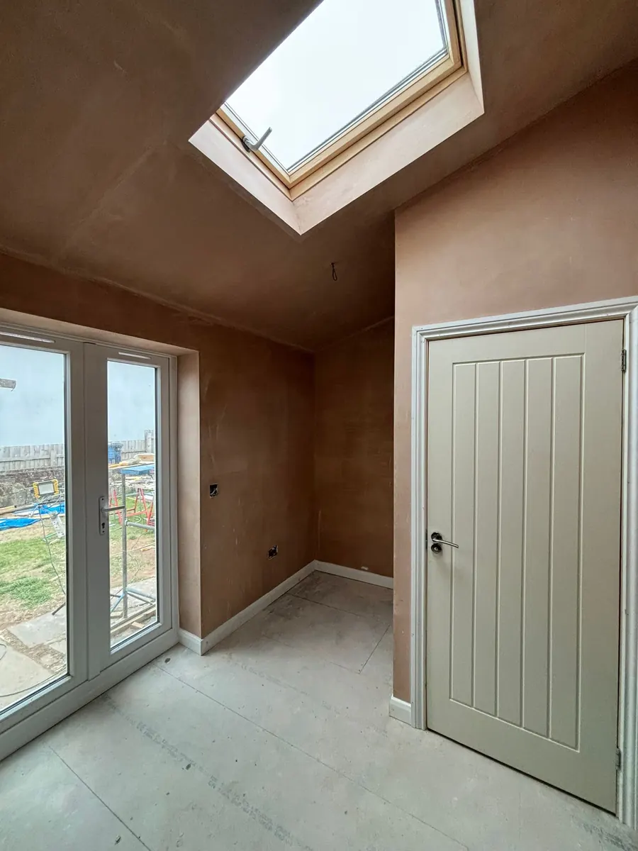 An extension plastered out with a roof light and french doors fitted, ready to decorate