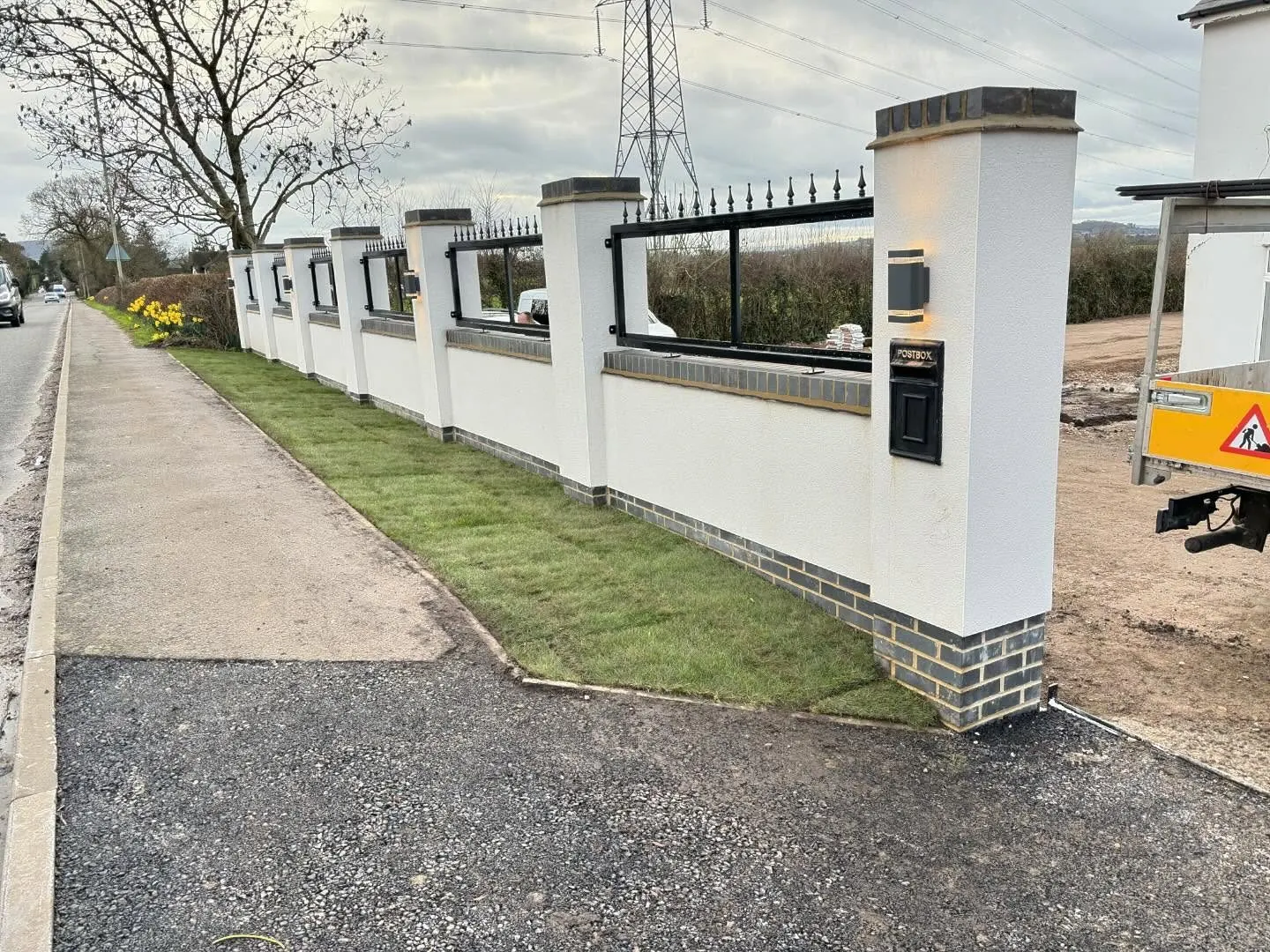 Finished rendered boundary wall with black railings on a Forest of Dean roadside