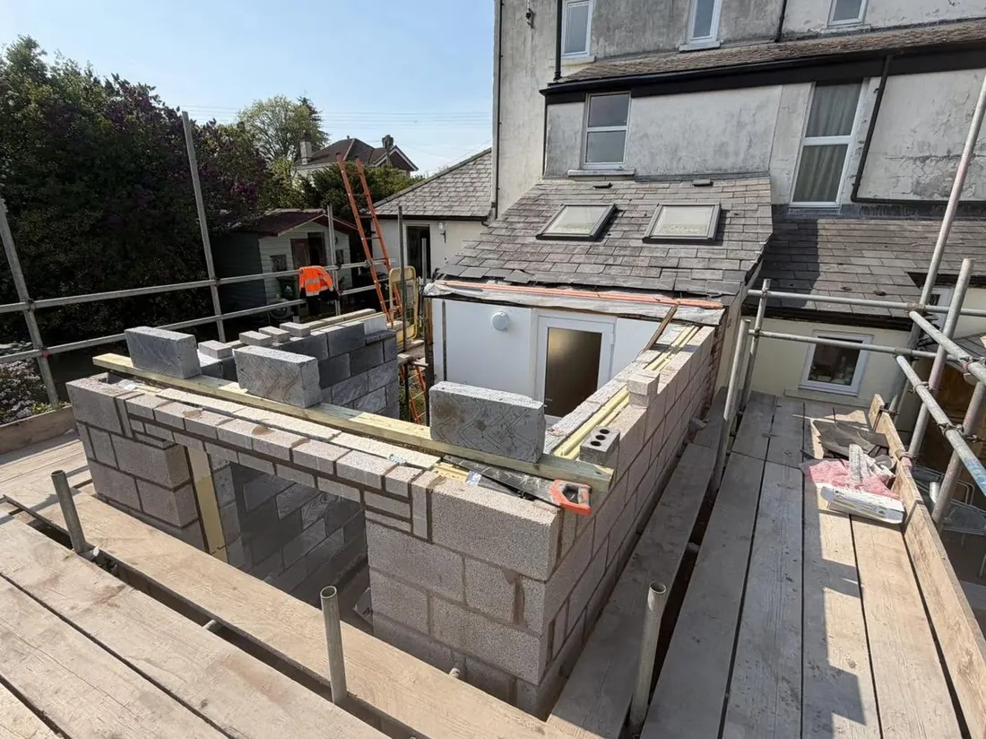 Extension blockwork under construction, tied into the existing brickwork and roofline